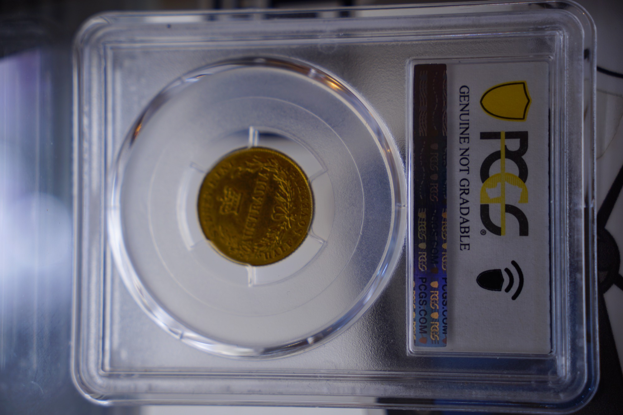 An 1855 Sydney Mint half sovereign in its PCGS holder, close up